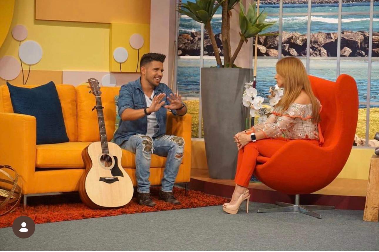 Edgar René durante una entrevista de televisión, con su guitarra al lado